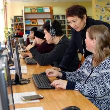 A librarian trains people with disability to use computers in the library.