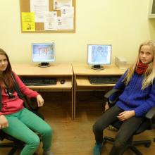Two girls with their computers, showing how they make animated films. 