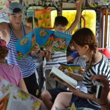 Children reading books inside the trolleybus.