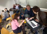 People sitting and working in groups at the open science trainer bootcamp in Debrecen, Hungary.