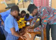 Librarian helping children with coding, using a puzzle. 