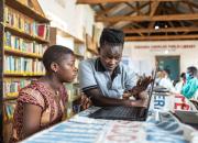 A teacher showing a young women how to use a computer in Caezxaria Public Library in Uganda. 
