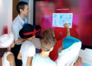 Children in the bank using a touch screen to learn about bank services