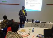 Velenasi Mwale Munsanje wecoming trainers, using a PowerPoint presentation.