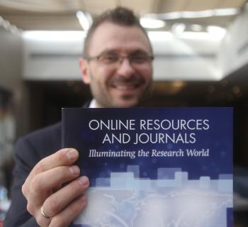 An EIFL publisher partner holds up a pamphlet about e-resources at the EIFL General Assembly