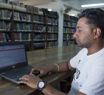 Researcher at a computer, in the library.