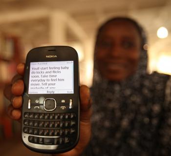 A pregnant woman at Northern Regional Library in Ghana shows her mobile phones, where she receives health information.