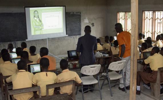 Children learning to use computers in a school classroom in Ghana. 