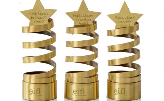 Three innovation award trophies - a golden spiral design, with a star on top.