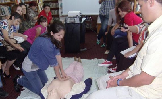 Library trainees practise using the First Aid dummy.