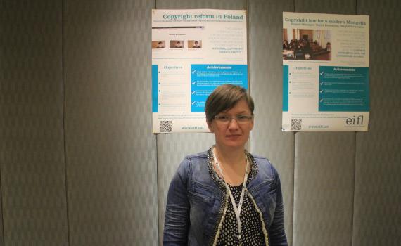 Project Manager, Barbara Szczepanska in front of poster of case study