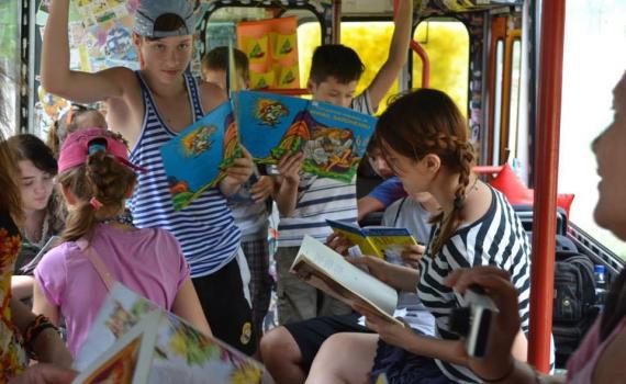 Children reading books inside the trolleybus.