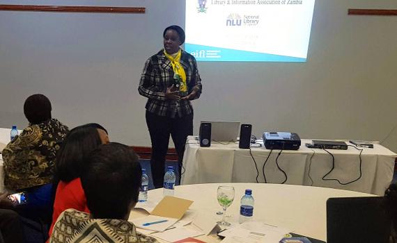 Velenasi Mwale Munsanje wecoming trainers, using a PowerPoint presentation.